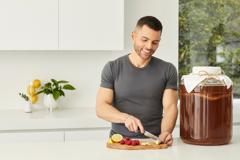 GT Dave cutting fruit with kombucha jar