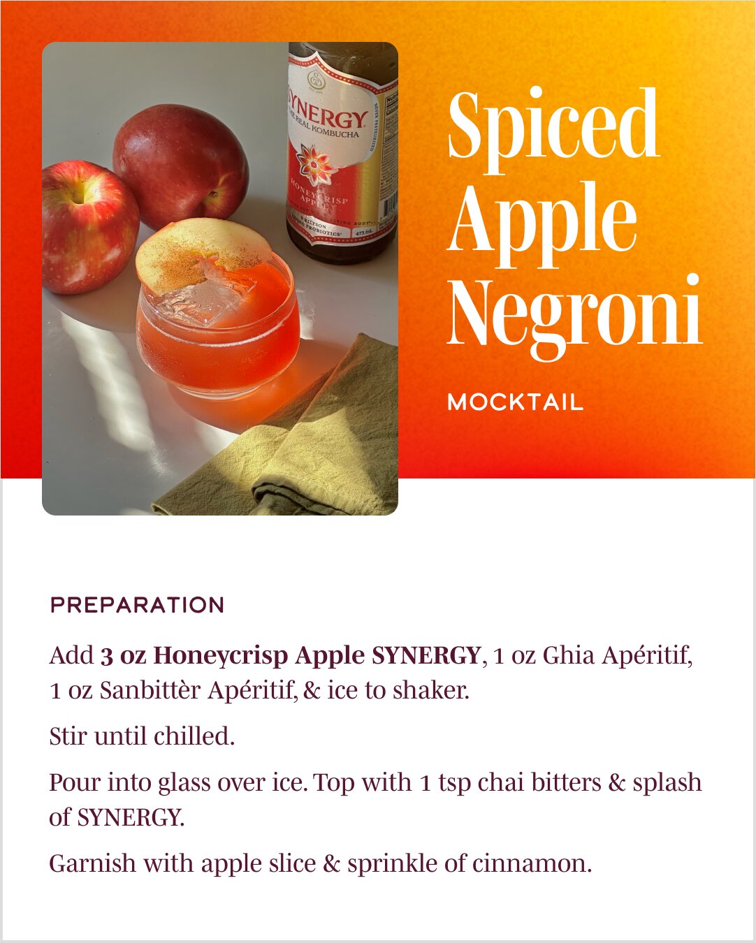 Spiced Apple Negroni preparation: add 3 oz Honeycrisp Apple Synergy, 1 oz Ghia Apéritif, 1 oz Sanbittèr Apéritif and ice to a shaker, stir until chilled, pour over ice, top with chai bitters and a splash of Synergy, and garnish with an apple slice and cinnamon.